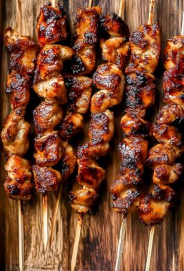 Top view of juicy grilled Thai coconut chicken skewers on a wooden serving tray