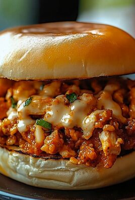 Close-up of Cajun chicken sloppy joe sandwich with spicy sauced chicken and melted cheese on a toasted bun
