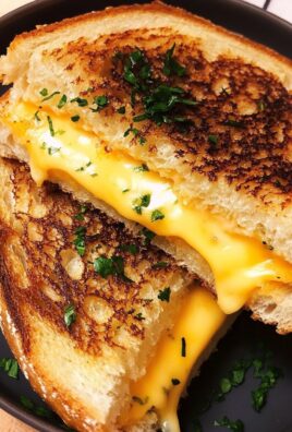 Golden grilled cheese sandwich made with garlic bread and melted cheddar, garnished with herbs