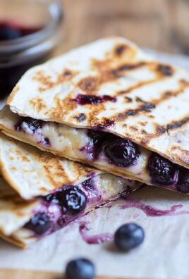 Close-up of grilled blueberry breakfast quesadilla with melted cheese and fresh blueberries